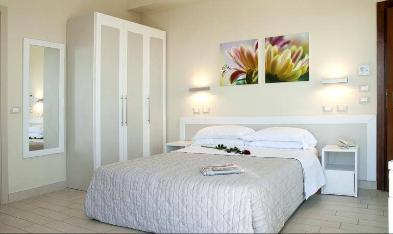 Camera moderna con letto matrimoniale e decorazioni floreali.