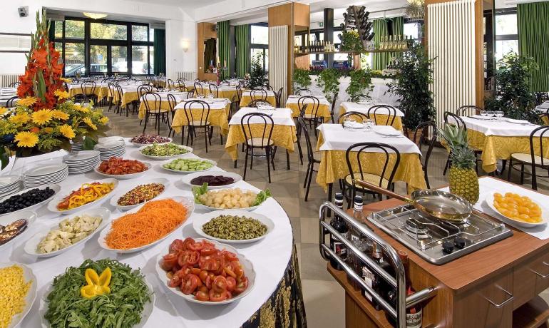 Ristorante elegante con buffet di verdure fresche e tavoli apparecchiati.