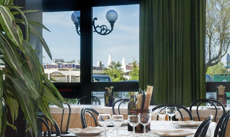 Restaurant élégant avec tables dressées et vue extérieure.